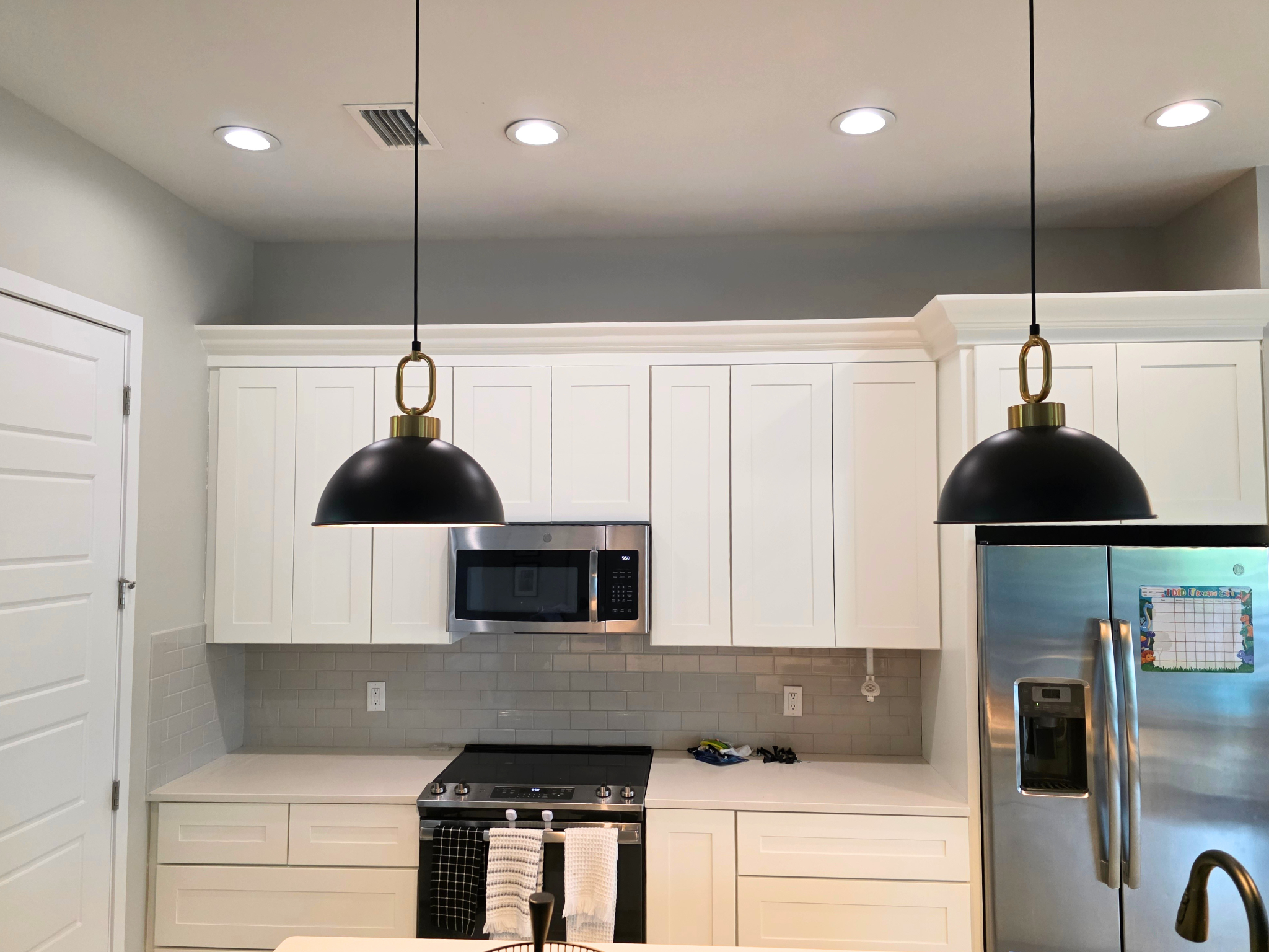 Alabaster kitchen cabinets with black pendant lights after cabinet painting in Southwest Cape Coral