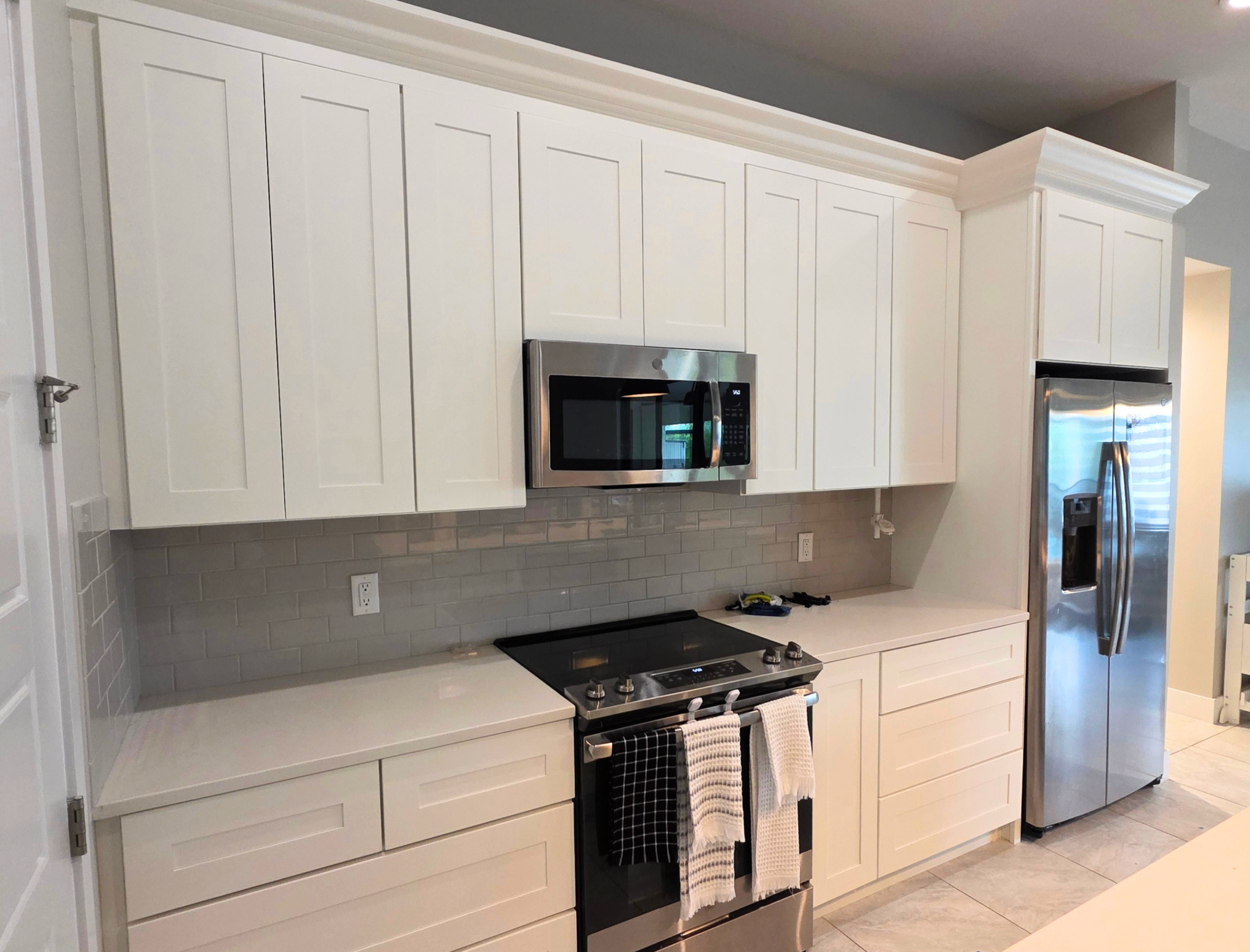 Kitchen cabinets painted Alabaster beside stainless steel appliances in Southwest Cape Coral